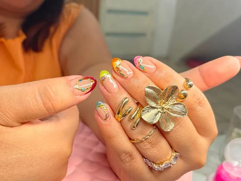 Uñas almendradas con diseño floral y detalles dorados